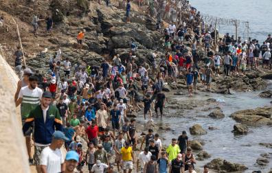 Jóvenes regresan a Marruecos por el mar en el paso fronterizo de Bab Sebta, tras haber protagonizado una entrada masiva irregular a Ceuta