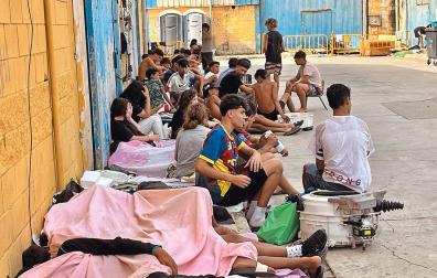 Varias decenas de migrantes descansan en una calle de Ceuta tras los cruces masivos a pie y por mar desde Marruecos