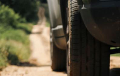 Un vehículo circula por un camino rural