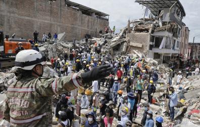 Una rescatista del Ejercito de Colombia da indicaciones a un grupo de voluntarios que realiza labores de búsqueda en edificaciones destruidas por el terremoto de magnitud 7,4 del pasado lunes, este miércoles en Pereira (Colombia)