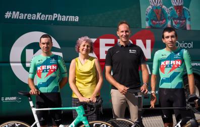 Los ciclistas Ibon Ruiz y Diego Uriarte flanquean, delante del autobús del equipo, a Rebeca Esnaola (consejera del Gobierno de Navarra) y a Juanjo Oroz (mánager general del Kern Pharma).