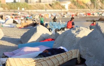 Migrantes acampan en la playa de El Trampolín, en Ceuta, este jueves
