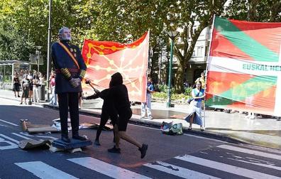 Varios manifestantes encapuchados derriban una estatua del Rey Felipe VI