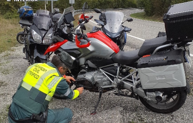 Un agente de la Guardia Civil, junto a la motocicleta accidentada