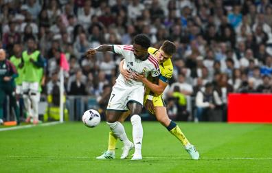 El delantero del Real Madrid Vinicius Jr (delante) lucha por el balón con Juan Foyth (detrás), del Villarreal CF, durante el partido