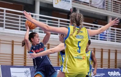 Celia García, nuevo fichaje del Osés Construcción, trata de conceder un pase ante la defensa de dos jugadoras del Spar Gran Canaria