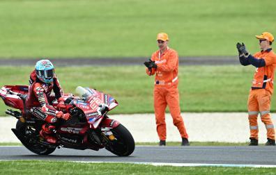 Dos empleados de Phillip Island aplauden a Marc Márquez tras su victoria en la carrera al sprint del GP de Australia