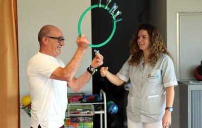 Jesús Manuel Gil Ochoa con su terapeuta ocupacional, Iratxe Garín, en el gimnasio del Hospital San Juan de Dios