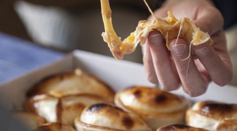 Un persona consume una empanada argentina de Las de Pichi Un persona consume una empanada argentina de Las de Pichi