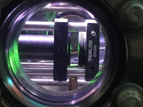 El diminuto punto verde en el centro de la imagen es un nanodiamante (aproximadamente 0,00000004 m) que levita en vacío gracias a la acción de un láser infrarrojo focalizado (pinzas ópticas). Experimento llevado a cabo por A. C. Frangeskou, A. T. M. A. Ra El diminuto punto verde en el centro de la imagen es un nanodiamante (aproximadamente 0,00000004 m) que levita en vacío gracias a la acción de un láser infrarrojo focalizado (pinzas ópticas). Experimento llevado a cabo por A. C. Frangeskou, A. T. M. A. Rahman, L. Gines, S. Mandal, O. A. Williams, P. F. Barker y G. W. Morley.