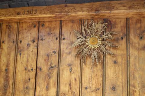 Eguzkilore (Carlina ceretana), flor del cardo silvestre, colgada en una casa de 1903 del Pirineo catalán (Cerdaña). Eguzkilore (Carlina ceretana), flor del cardo silvestre, colgada en una casa de 1903 del Pirineo catalán (Cerdaña).