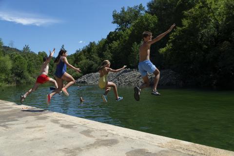 Cuatro menores saltan al agua en la piscina natural de Ochagavía Ochagavía