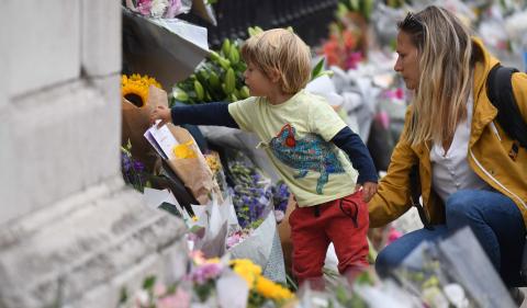 Un niño mira las ofrendas florales que se encuentran a las afueras del palacio de Buckingham en Londres Un niño mira las ofrendas florales que se encuentran a las afueras del palacio de Buckingham en Londres