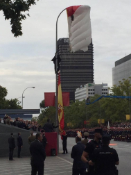 El paracaidista que descendía con la bandera de España que se iza para el desfile de la Fiesta Nacional ha impactado contra una farola del paseo de la Castellana de Madrid, junto al palco de las autoridades, y ha quedado atrapado allí unos minutos.