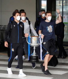 Cientos de aficionados de la Real Sociedad han aguardado en los márgenes de la carretera que conecta el aeropuerto de Hondarribia con San Sebastián para saludar a los campeones de la Copa del Rey.