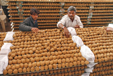 Trabajadores disponen 'laddus' (dulces) en una cocina en Ahmedabad, una ciudad al oeste de la India. Más de 300.000 'laddus' fueron fabricados para el banquete de una ceremonia religiosa organizada para el Brahmins, la casta superior de hindús.
