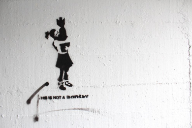 Grafitis de similar estética a la del famoso grafitero internacional Banksy decoran las paredes del tunel que une la calle Esquiroz con la Universidad de Navarra