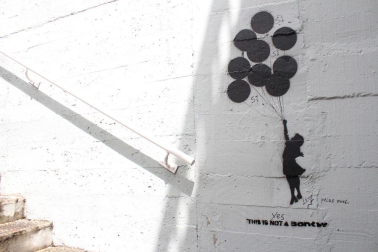 Grafitis de similar estética a la del famoso grafitero internacional Banksy decoran las paredes del tunel que une la calle Esquiroz con la Universidad de Navarra