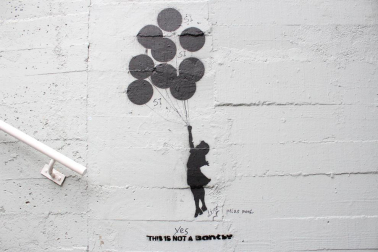 Grafitis de similar estética a la del famoso grafitero internacional Banksy decoran las paredes del tunel que une la calle Esquiroz con la Universidad de Navarra