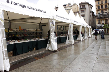 Mal tiempo en la inauguración de la XII Feria del Libro de Pamplona, con los visitantes acudiendo a los puestos de la Plaza del Castillo.