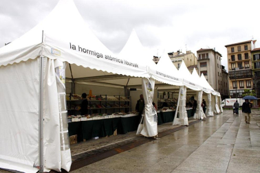 Mal tiempo en la inauguración de la XII Feria del Libro de Pamplona, con los visitantes acudiendo a los puestos de la Plaza del Castillo.