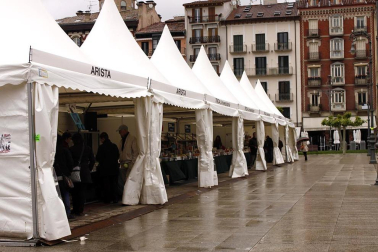 Mal tiempo en la inauguración de la XII Feria del Libro de Pamplona, con los visitantes acudiendo a los puestos de la Plaza del Castillo.