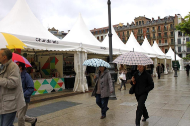 Mal tiempo en la inauguración de la XII Feria del Libro de Pamplona, con los visitantes acudiendo a los puestos de la Plaza del Castillo.