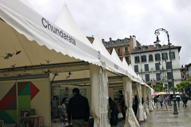 Mal tiempo en la inauguración de la XII Feria del Libro de Pamplona, con los visitantes acudiendo a los puestos de la Plaza del Castillo.