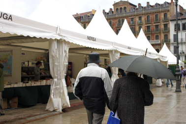 Mal tiempo en la inauguración de la XII Feria del Libro de Pamplona, con los visitantes acudiendo a los puestos de la Plaza del Castillo.
