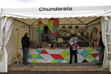 Mal tiempo en la inauguración de la XII Feria del Libro de Pamplona, con los visitantes acudiendo a los puestos de la Plaza del Castillo.