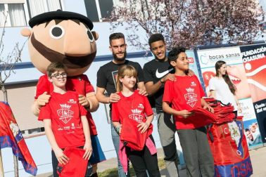 Los jugadores Roberto Torres y Antonio Otegui estuvieron con los alumnos del colegio Griseras y acudieron al centro cívico del barrio de Lourdes.