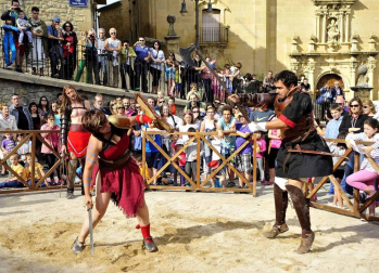 Imágenes de lucha de gladiadores romanos, representación de una boda, mercadillo y otras actividades en Mendigorría.