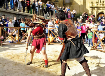 Imágenes de lucha de gladiadores romanos, representación de una boda, mercadillo y otras actividades en Mendigorría.