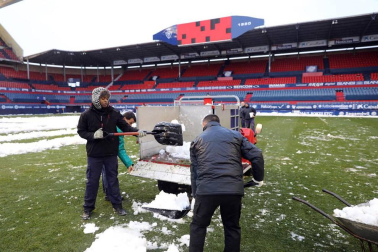 Operarios de Osasuna, del ISN y voluntarios de Sadar Bizirik limpiaron la nieve del terreno de juego horas antes de la disputa del Osasuna-Valladolid, aplazado por las nevadas.