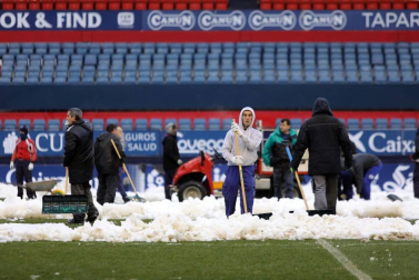 Operarios de Osasuna, del ISN y voluntarios de Sadar Bizirik limpiaron la nieve del terreno de juego horas antes de la disputa del Osasuna-Valladolid, aplazado por las nevadas.
