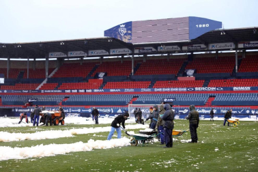 Operarios de Osasuna, del ISN y voluntarios de Sadar Bizirik limpiaron la nieve del terreno de juego horas antes de la disputa del Osasuna-Valladolid, aplazado por las nevadas.