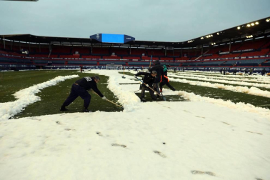 Operarios de Osasuna, del ISN y voluntarios de Sadar Bizirik limpiaron la nieve del terreno de juego horas antes de la disputa del Osasuna-Valladolid, aplazado por las nevadas.