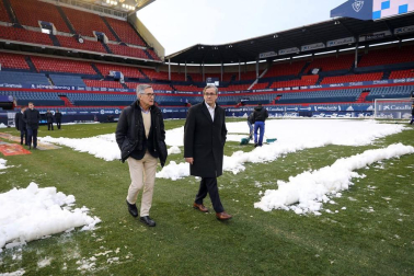 Operarios de Osasuna, del ISN y voluntarios de Sadar Bizirik limpiaron la nieve del terreno de juego horas antes de la disputa del Osasuna-Valladolid, aplazado por las nevadas.