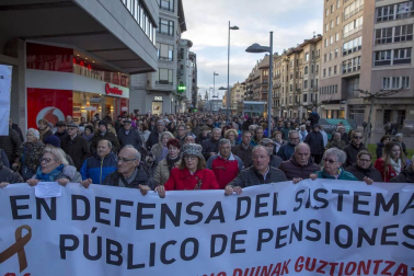 Jóvenes y mayores salen a la calle en Pamplona bajo la lluvia