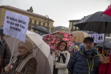 Jóvenes y mayores salen a la calle en Pamplona bajo la lluvia