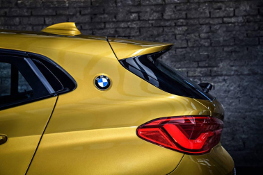 La imagen aguerrida del BMW X1 refuerza su apuesta diferenciadora, como se aprecia en las llantas, la alta línea de cintura y el frontal. Su baja altura diluye su estética SUV. El detalle del logo de la marca en el tercer pilar y el alerón trasero son un guiño juvenil.