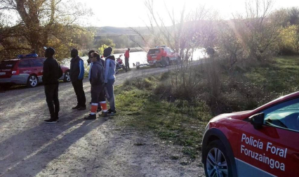 Agentes de Policía Foral y Bomberos de Navarra realizan la búsqueda del desaparecido tras caer al río en Lodosa.