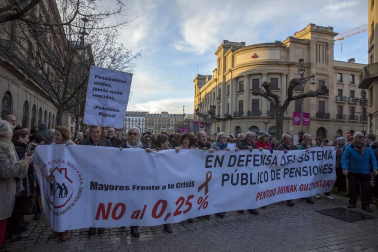 Jóvenes y mayores salen a la calle en Pamplona bajo la lluvia