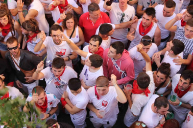 Una moza ataviada de San Fermín se ha encaramado a la hornacina para dirigir los últimos ruegos al Santo en el particular encierro del 15 de julio
