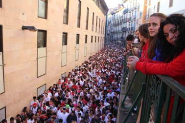 Una moza ataviada de San Fermín se ha encaramado a la hornacina para dirigir los últimos ruegos al Santo en el particular encierro del 15 de julio