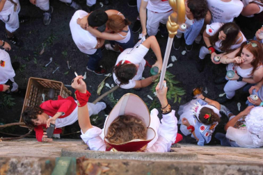 Una moza ataviada de San Fermín se ha encaramado a la hornacina para dirigir los últimos ruegos al Santo en el particular encierro del 15 de julio