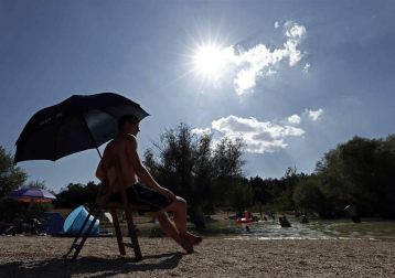Varias personas se alivian del calor en el pantano de Alloz y en el río Arga a su paso por Irotz.
