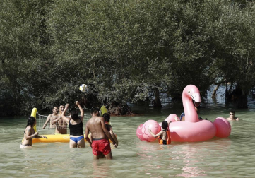 Varias personas se alivian del calor en el pantano de Alloz y en el río Arga a su paso por Irotz.