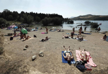 Varias personas se alivian del calor en el pantano de Alloz y en el río Arga a su paso por Irotz.
