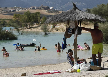 Varias personas se alivian del calor en el pantano de Alloz y en el río Arga a su paso por Irotz.